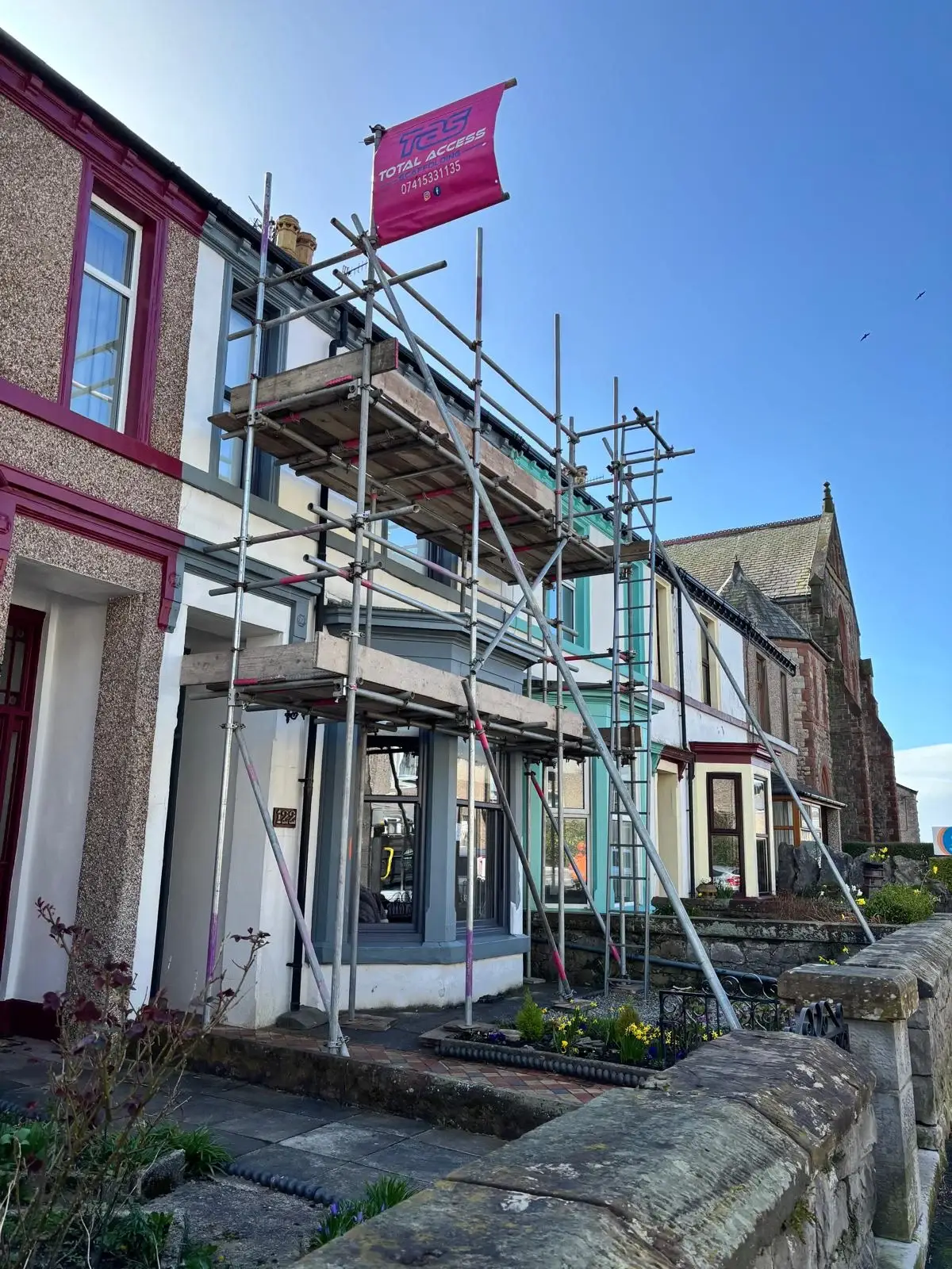 Independent scaffold tower on pebble-dashed house for render repairs in Walney