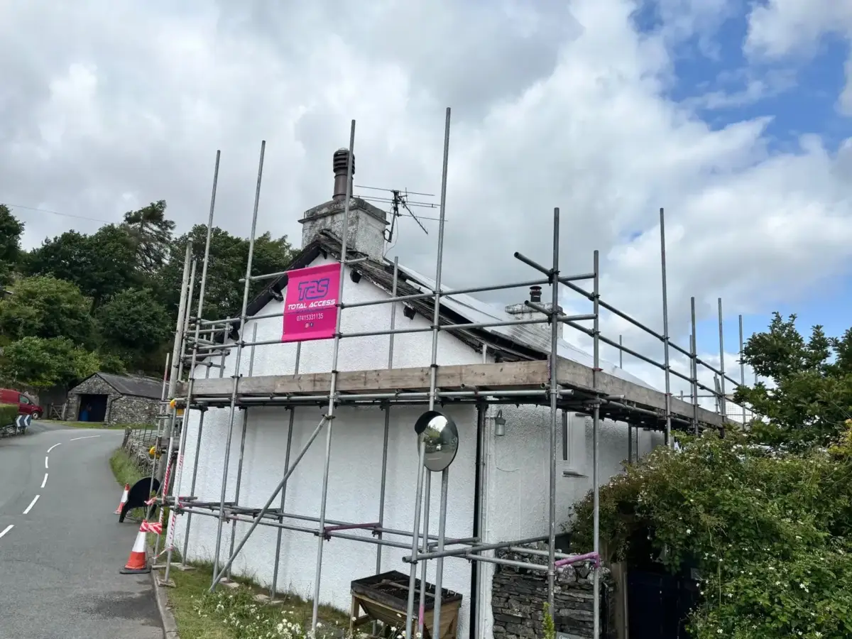 Scaffolding house wrap on detached home for external wall repair in South Lakes